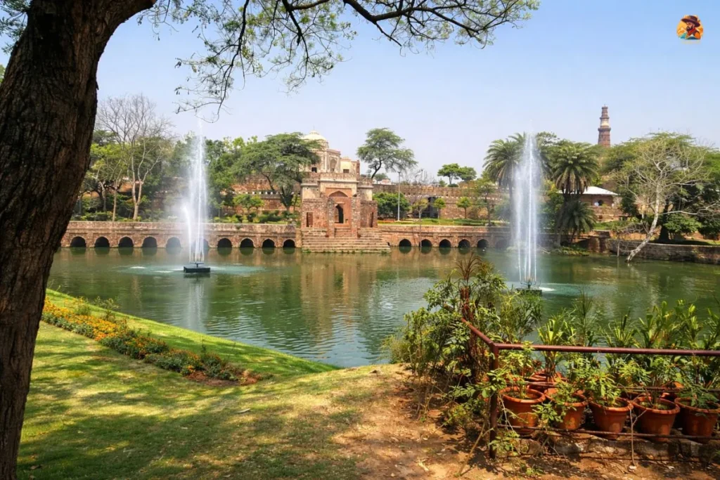 Lake view of Mehrauli Archaeological Park with bridge, fountains and Qutub Minar in Delhi